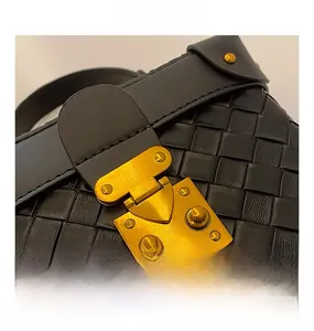 Close-up of black woven leather handbag showing vintage gold metal hardware buckle details