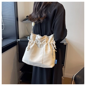 Détail du sac cabas plissé crème montrant le cordon et la texture en cuir souple