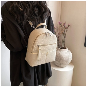 Close-up of cream lychee texture mini backpack with adjustable straps on model