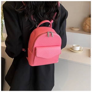 Close-up of bright pink pleated ballet style backpack with litchi grain leather texture