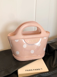 Pink polka dot bucket bag with gold lettering and integrated handle design