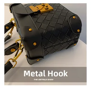Close-up of woven leather bucket bag featuring gold hardware hooks and rivets