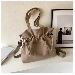 Détail du sac fourre-tout en toile kaki avec cordon de serrage et bandoulière réglable