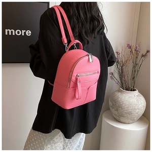 Detail of pink mini backpack with pebbled leather texture and silver zipper hardware