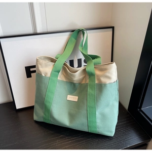 Close-up of contrast color canvas tote bag featuring premium leather logo patch