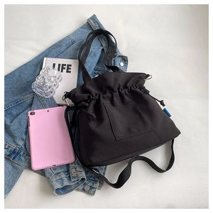 Vue de dessus d'un grand sac cabas en toile noire avec cordon et tablette de style