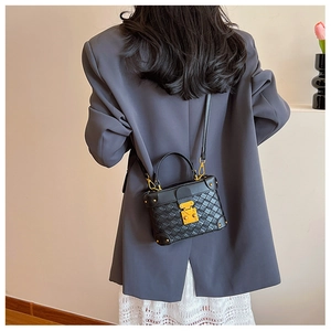Classic black quilted crossbody bucket bag with gold hardware shown on model back