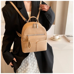 Detailed macro view of the beige mini backpack featuring premium lychee pattern texture