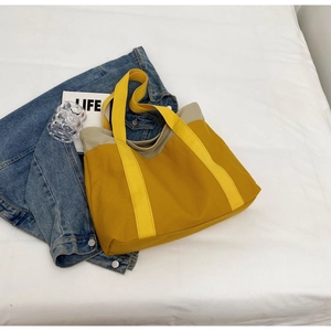 Flat lay of a large canvas tote bag in contrast yellow and khaki with durable strap