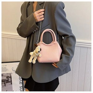 Détail du sac seau en cuir grainé rose avec chaîne argentée et charm de chiot