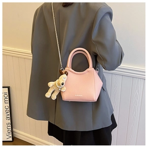 Détail du sac seau en cuir grainé rose avec pendentif chien et chaîne en métal