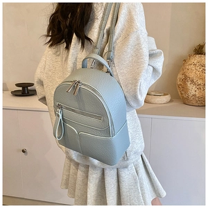 Detailed side view of a light blue mini leather backpack featuring textured finish