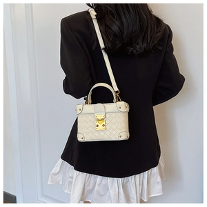 Detail of white box bag with woven pattern, gold hardware and leather crossbody strap
