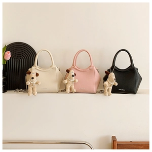 Trois mini sacs seaux en crème, rose et noir avec des breloques de chien en peluche
