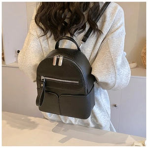 Detail view of mini black backpack in pebble leather texture with adjustable thin straps