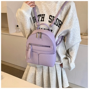 Mini lavender backpack with pebble leather texture worn by model in a casual outfit