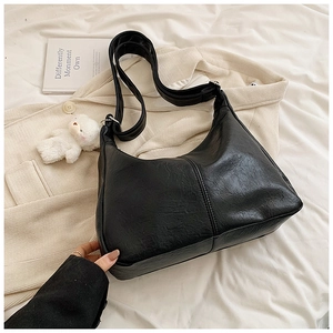 Détail du sac hobo noir avec texture cuir et pendentif ours blanc décoratif mignon