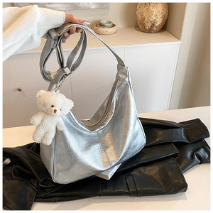 Détail du sac hobo argenté métallisé avec texture froissée et breloque ours en peluche