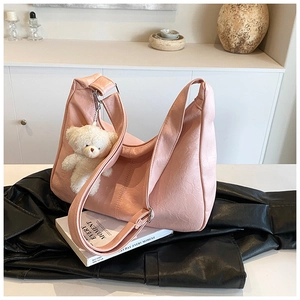 Détail du sac hobo rose en cuir PU avec large bandoulière et pendentif ours