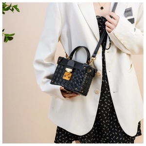 Detail of black woven leather bucket bag with gold metallic lock and hardware