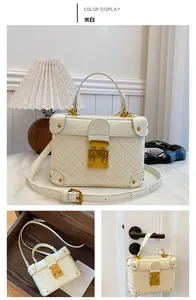 Detail view of cream bucket bag with woven texture and gold metal buckle hardware
