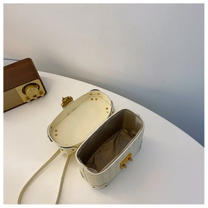 Interior view of white woven bucket bag showing lining and gold hardware accents