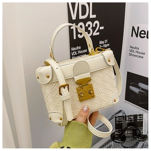 Detail of white woven leather bucket bag with gold clasp and adjustable strap