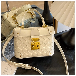 Detail of white woven box bag with vintage metallic clasp and protective corner rivets