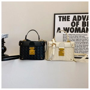 Close-up of stylish woven texture and vintage metal clasps on black and white bucket bags