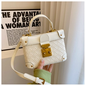 Detail of white woven mini bucket bag with gold hardware and stylish box design
