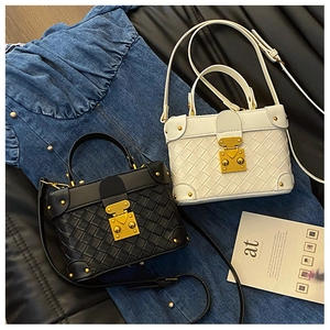 Detail of woven leather bucket bags with gold buckles and metallic rivet corners