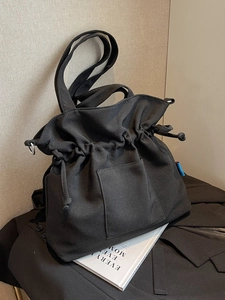 Grand sac cabas en toile noire plissée avec fermeture à cordon et poche frontale