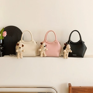 Trois mini sacs seaux en cuir blanc, rose et noir avec des breloques de chiots mignons