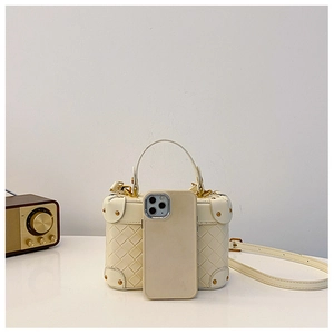 Cream white woven bucket bag detail showing metal rivets and smartphone for size reference