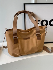 Large khaki canvas tote bag with brown leather handles and adjustable shoulder strap