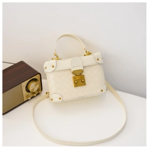 Detail of cream woven leather box bag with vintage gold clasp and rivet hardware
