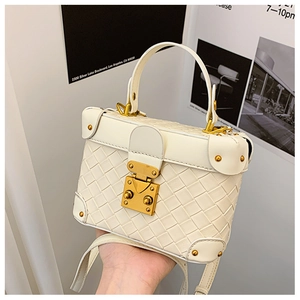 Detail of off-white woven texture box bag featuring vintage gold metal clasp and rivets