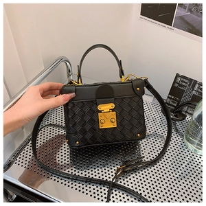 Detail of black woven box bag featuring vintage gold clasp and rivet trim details