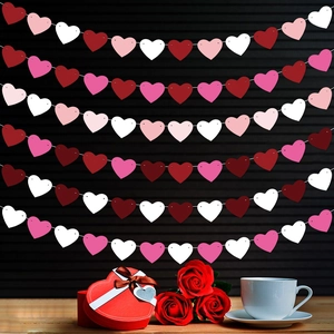 Valentine's heart banner with multilayered pink and red paper hearts over gift box decor