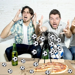 Soccer themed centerpiece with football cutouts and confetti for sports party table decor