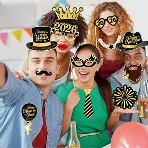 Cheerful group using 2026 New Year photo booth props in black and gold party theme