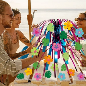 Tropical fountain centerpiece with hibiscus flowers and palm leaves on a sunny beach table