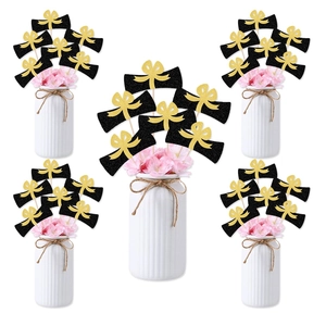 Graduation party centerpiece featuring black diploma picks with gold bows in white vases