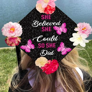 Glitter graduation cap topper with pink flowers and SHE Believed SHE Could slogan