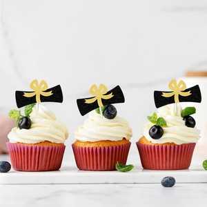 Graduation party cupcake toppers with black scroll and gold glitter bow decorations