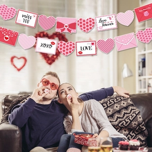 Close-up of Valentine banner with paper hearts, pink envelopes, and love letters for party decor