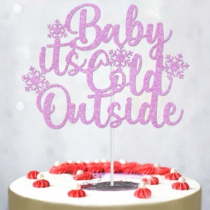Pink glittery Baby It's Cold Outside cake topper with snowflakes for winter parties
