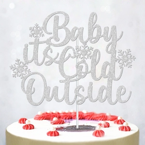 Silver glitter 'Baby it's Cold Outside' cake topper with snowflake decor for winter parties