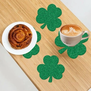 Close-up of four glittery green shamrock coasters on a wooden table for St. Patrick's Day