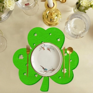 Green St. Patrick's Day shamrock felt placemat with clover cutouts on elegant dining table